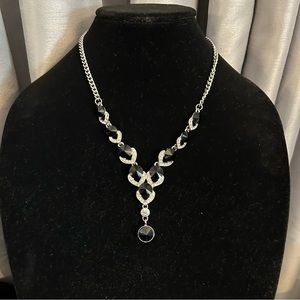 Elegant silver toned necklace set with high shine crystals in clear and black.